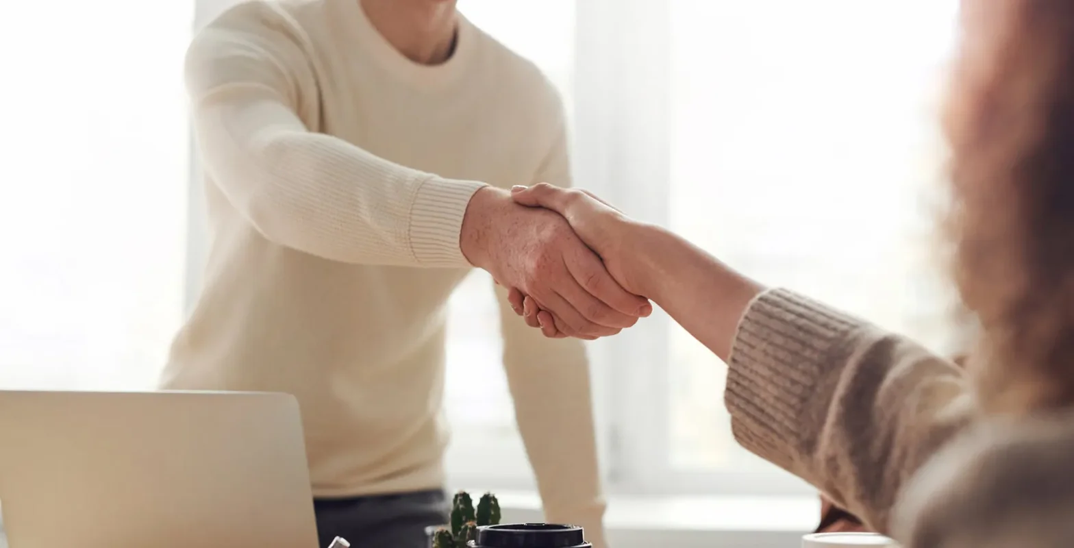 Professional and discreet reference check handshake across a desk